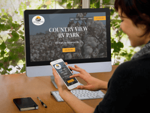 Person viewing RV park website on computer and phone